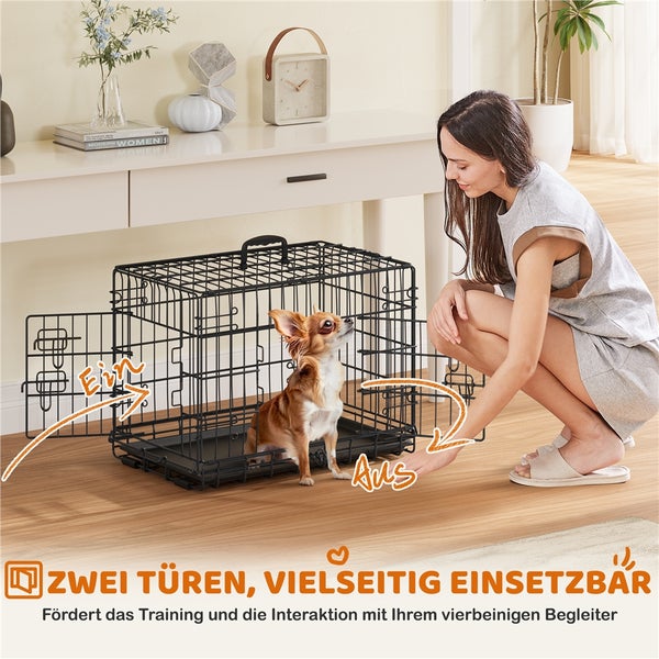 Eine Frau lässt einen Hund in eine schwarze Drahtgitter-Hundebox gehen