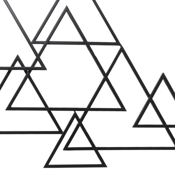 Geometrische Wanddekoration aus Metall mit ineinandergreifenden Dreiecken.