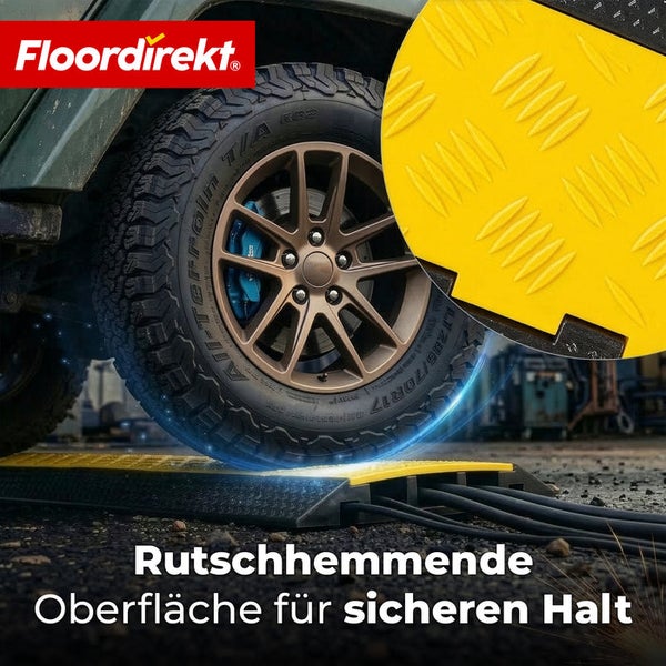 Kabelbrücke mit rutschhemmender Oberfläche und Floordirekt Logo. Ein Reifen überfährt den Kabelschutz mit mehreren Kabeln.