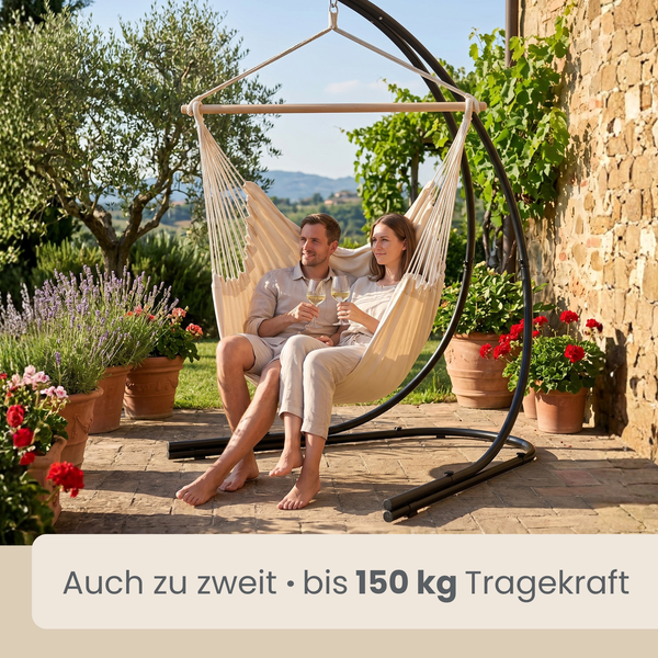 Hängesessel mit schwarzem Gestell, belastbar bis 150 Kilogramm, abgebildet mit zwei Personen auf einer sonnigen Terrasse mit Pflanzen.