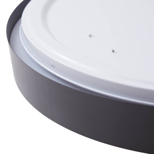 Nahaufnahme einer runden Deckenleuchte mit dunklem Außenring und weißem Sockel mit Befestigungsschrauben.