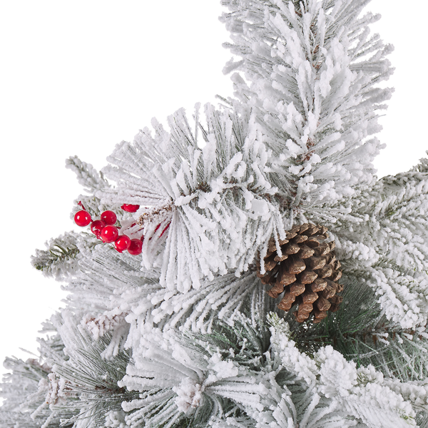 Detailansicht eines künstlichen Weihnachtsbaums mit künstlichem Schnee, Tannenzapfen und roten Beeren.