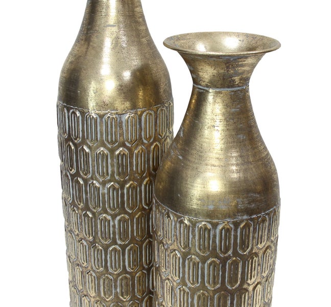 Zwei goldfarbene Metallvasen mit geometrischem Reliefmuster. Eine hohe Vase mit schmalem Hals und eine kürzere Vase mit weitem Rand.