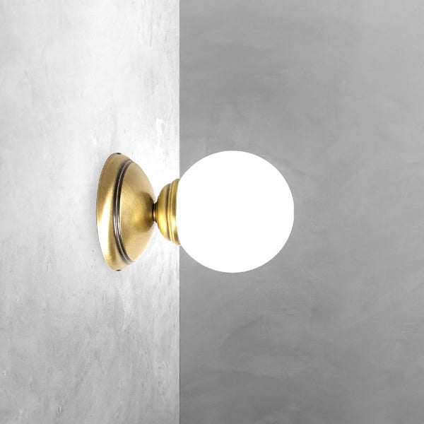 Wandleuchte mit runder Lichtquelle und Metallhalterung