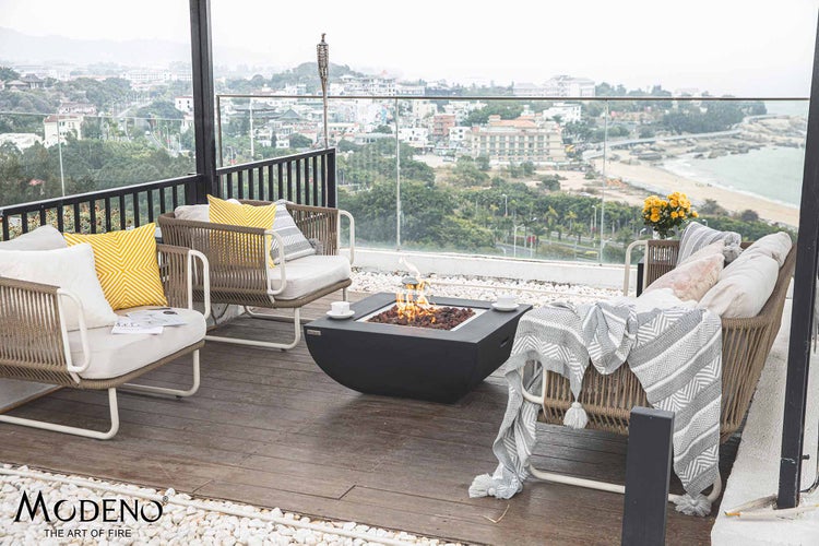 Moderne Dachterrasse mit quadratischer Gasfeuerstelle, Sesseln, Sofa und Stadtblick. Möbel aus Seilgeflecht. Modeno Logo.