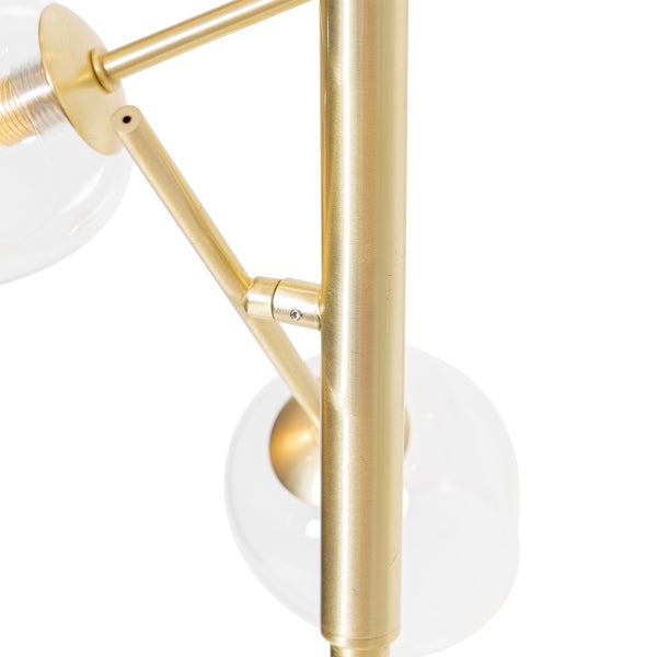 Detailaufnahme einer Stehlampe mit goldenem Gestell und Glaskugeln