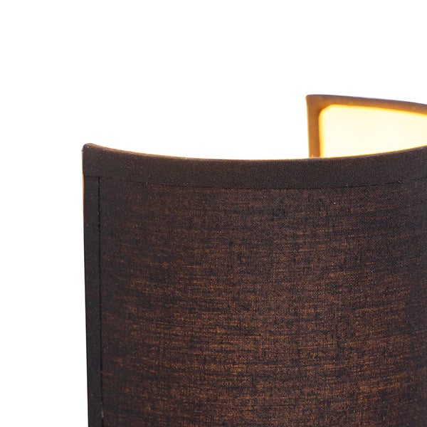 Detailaufnahme eines halbrunden Lampenschirms aus dunklem Stoff mit leuchtender Innenseite.