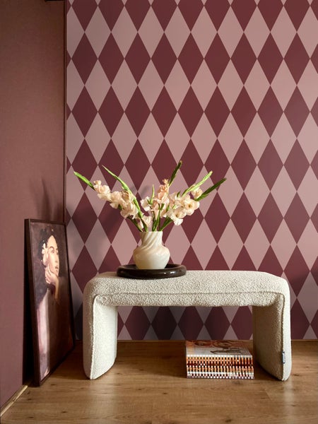 Dekoratives Interieur mit Rautenmuster Tapete, Sitzbank, Blumen und Gemälde