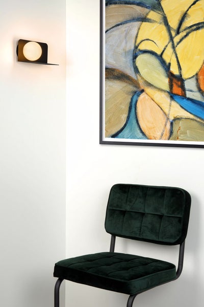 Szene mit Wandleuchte, abstraktem Bild und einem Stuhl mit Stoffbezug