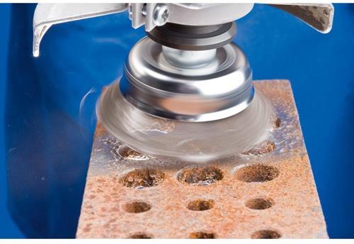 Eine Drahtbürste an einem Winkelschleifer reinigt eine rostige Metalloberfläche.