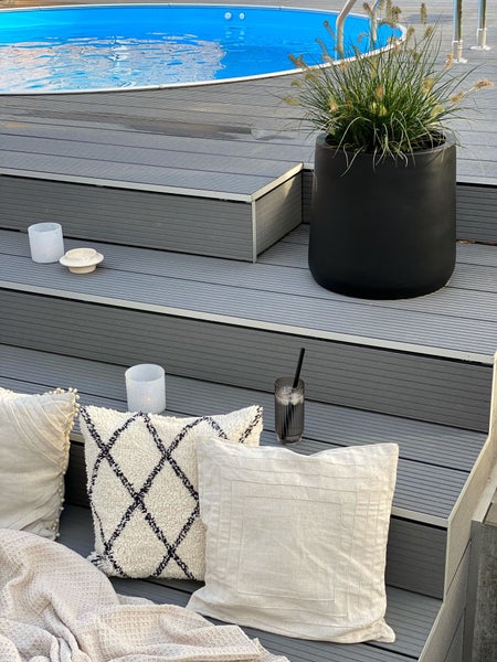 Schwarzer Pflanzkübel aus Fiberglas mit Hortensie im Wohnzimmer. Maße: Höhe 40 Zentimeter, Durchmesser oben 38 Zentimeter, unten 43 Zentimeter.