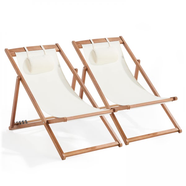 Zwei Liegestühle aus Holz mit cremefarbenem Textilbezug und Kopfkissen.