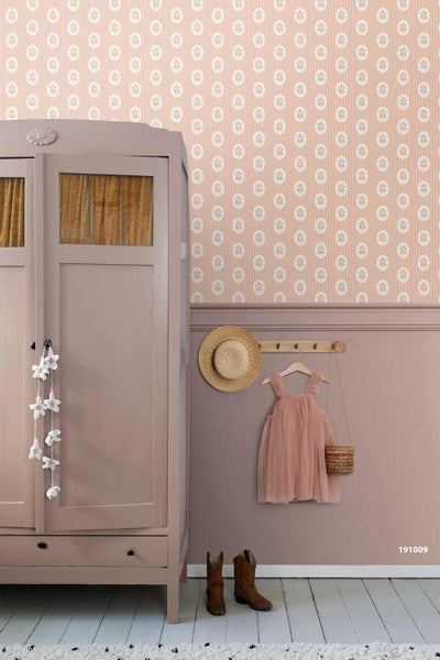 Kinderzimmer mit gemusterter Tapete über einer Wandleiste, einem Kleiderschrank und einer Garderobe mit Hut und Kleid.