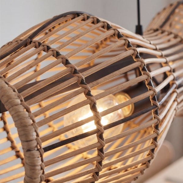 Detailansicht einer Pendelleuchte mit einem Schirm aus geflochtenem Rattan und einer eingeschalteten Glühbirne für warmes Licht.