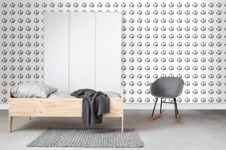 Kinderzimmer mit Holzbett, Kleiderschrank und Fußballtapete