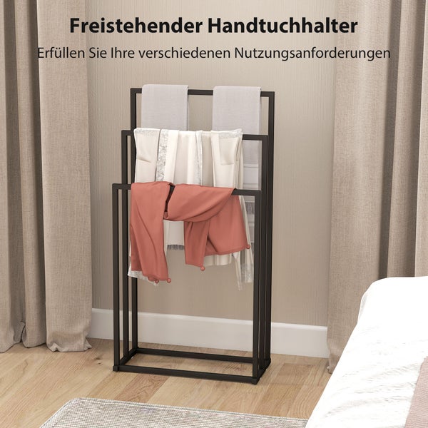 Freistehender Handtuchhalter aus schwarzem Metall mit drei Stangen auf unterschiedlichen Höhen, behängt mit Textilien in einem hellen Raum.