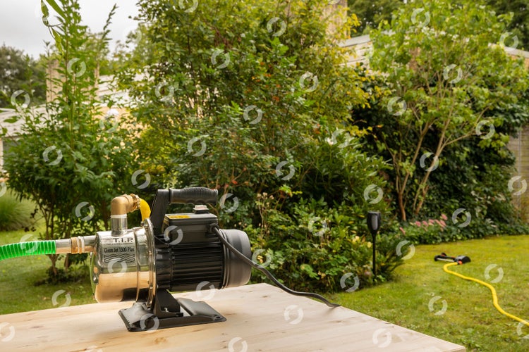 Tiefbrunnenpumpe auf einem Holztisch im Garten