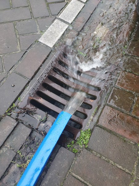 Blauer Flachschlauch aus Kunststoff, aufgerollt.