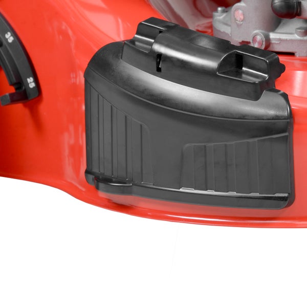 Detailansicht eines Rasenmähers mit rotem Gehäuse, schwarzer Seitenauswurfklappe und Hebel zur Schnitthöhenverstellung.