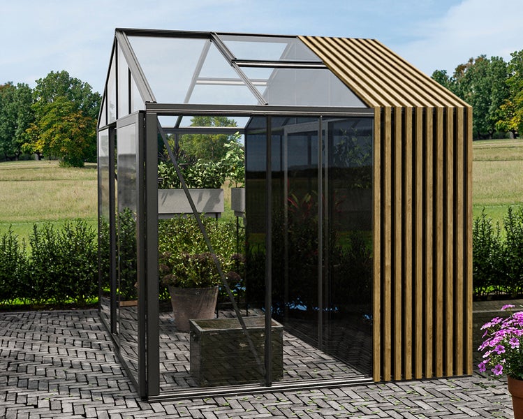 Modernes Gewächshaus aus Glas und Metall mit Holzlamellen an einer Seite und auf dem Dach, stehend auf einer gepflasterten Terrasse.