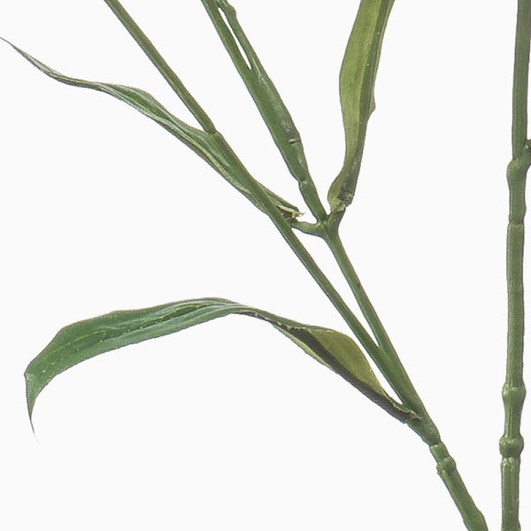 Detailaufnahme eines künstlichen Bambuszweiges mit schmalen grünen Blättern und gegliedertem Stiel.