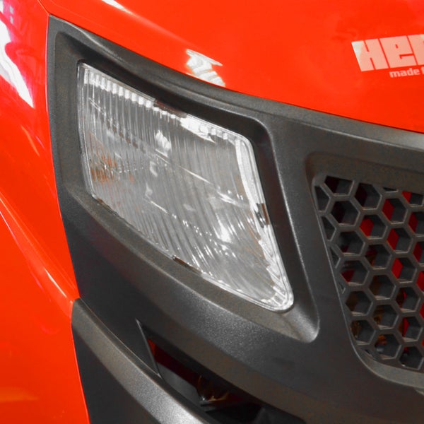 Nahaufnahme des Scheinwerfers und des Kühlergrills eines Aufsitzmähers