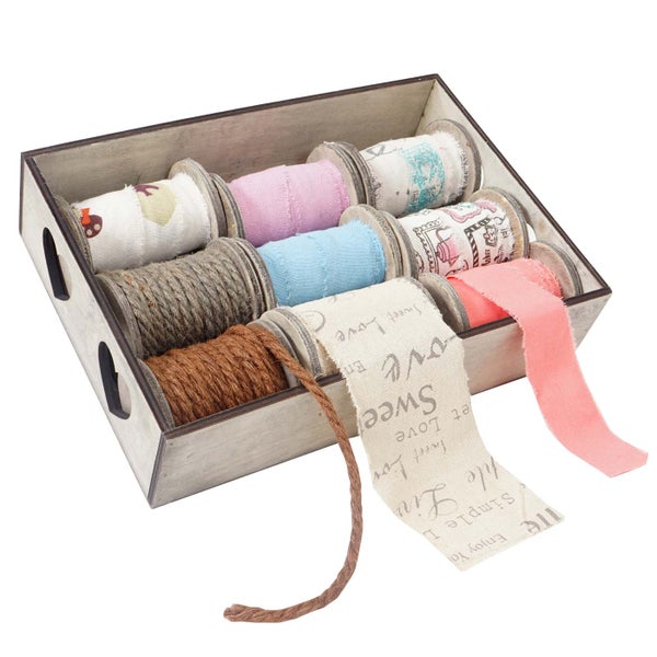 Kiste mit Spulen von dekorativem Band und Kordel
