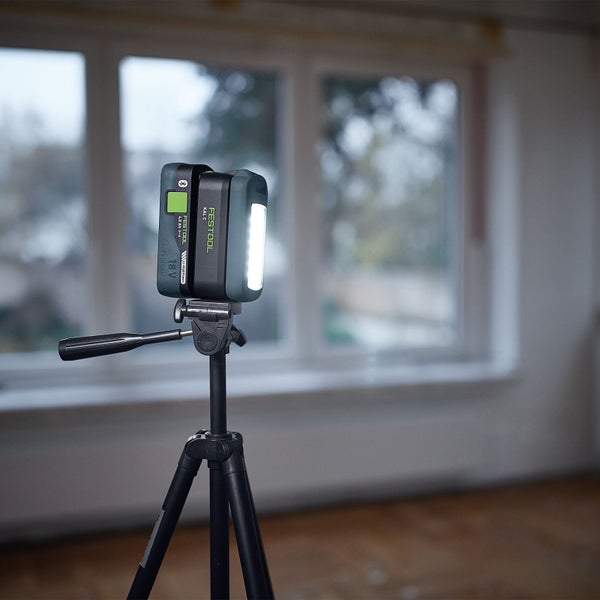 Eine Person arbeitet mit einem Schraubendreher an einem Sicherungskasten, beleuchtet von einer Festool Arbeitsleuchte.