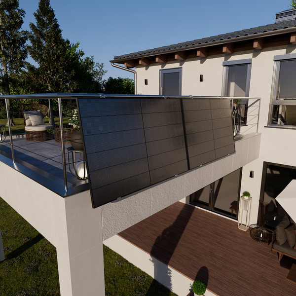 Modernes Balkonkraftwerk mit zwei Solarmodulen am Edelstahlgeländer eines hellen Hauses mit Blick auf eine Holzterrasse.