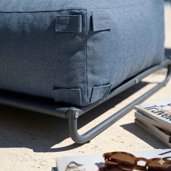 Detailaufnahme eines blauen Outdoor-Sitzkissens mit Laschen zur Befestigung an einem grauen Metallgestell.