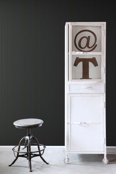 Szene mit einem Hocker, einem weißen Schrank mit Fächern und Dekorationsgegenständen.