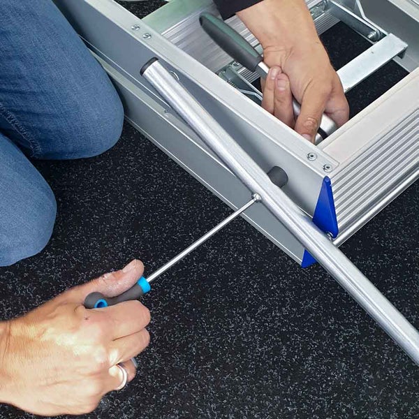 Montage einer Aluminiumleiter mit Schraubendreher.