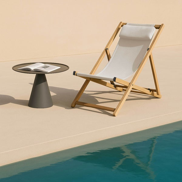 Klappbarer Liegestuhl aus Holz mit beigefarbenem Textilbezug und Kopfpolster.
