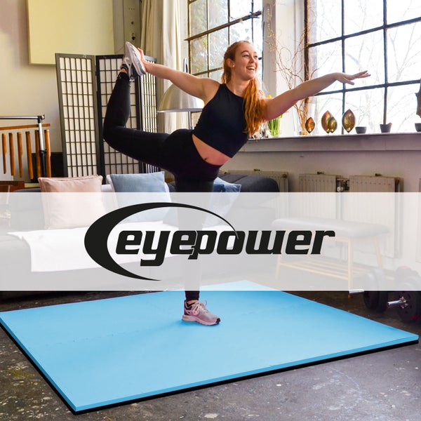 Eine Frau macht Yoga auf einer rechteckigen Eyepower Steckmatte in einem hellen, weitläufigen Raum.