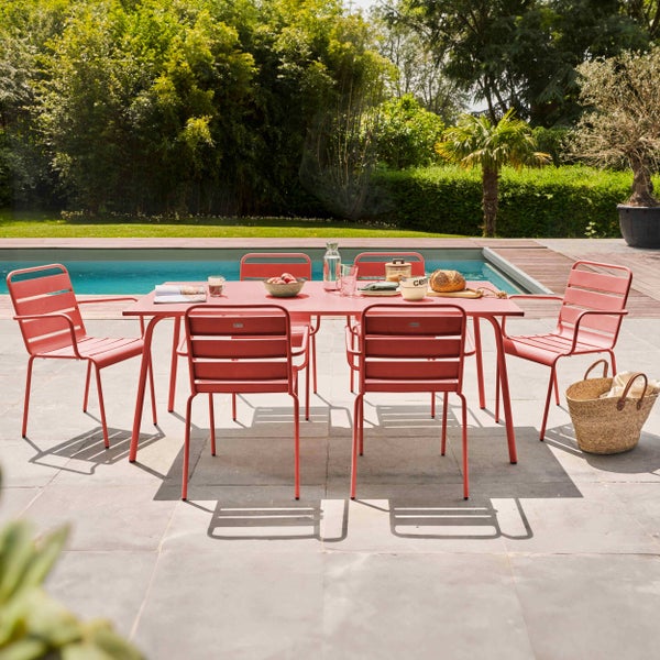 Modernes Gartenmöbel-Set aus Metall mit rechteckigem Tisch und Stühlen auf einer Terrasse neben einem Pool im Garten.