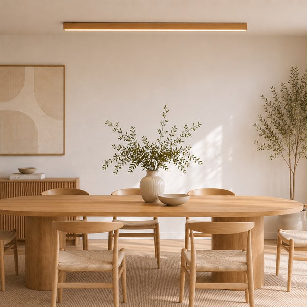 Esszimmer im skandinavischen Stil mit langem Holztisch, Stühlen mit Geflecht, einer Deckenleuchte aus Holz und dekorativen Pflanzen.