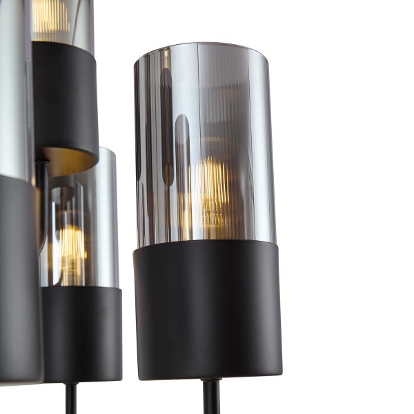 Nahaufnahme einer Lampe mit grauen Glasschirmen und schwarzer Basis.