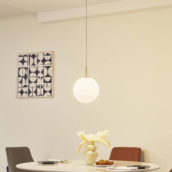 Moderne Pendelleuchte mit weißer Glaskugel über einem runden Marmortisch in einem hellen, minimalistisch eingerichteten Esszimmer.