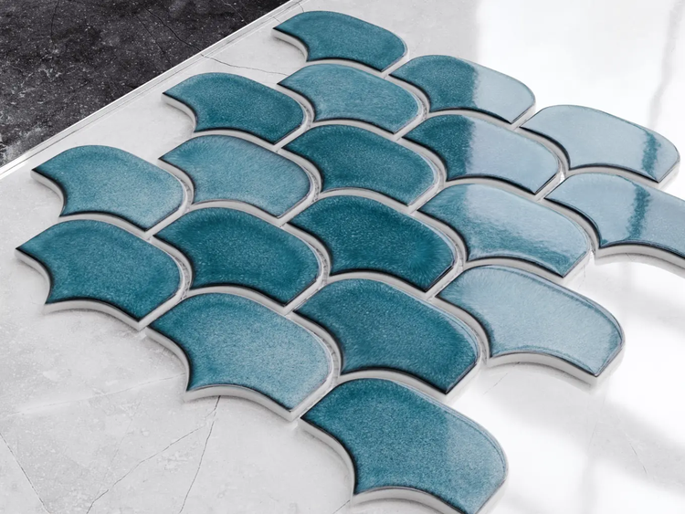 Blaue Mosaikfliesen in Schuppenform mit glänzender, strukturierter Oberfläche.