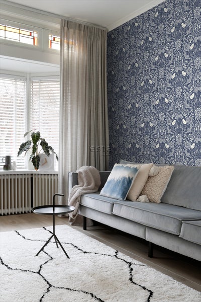 Wohnzimmer mit Sofa, Teppich und gemusterter Tapete