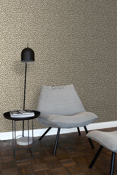 Szene mit gemusterter Tapete, Sessel, Fußhocker, Stehlampe und Beistelltisch für Wohnraumgestaltung