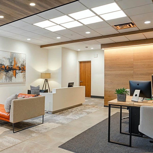 Empfangsbereich mit Schreibtisch, Sitzgelegenheiten und Büromöbeln