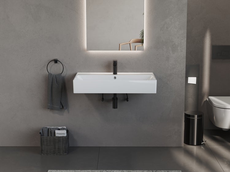 Badezimmer mit weißem Waschbecken, Spiegel mit Beleuchtung und Badaccessoires.