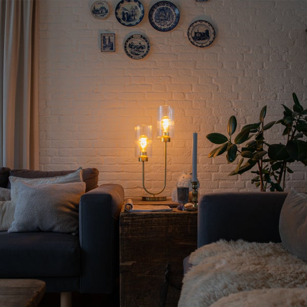 Dekorative Wohnzimmerszene mit Stehlampe, Sofa und Wanddeko.