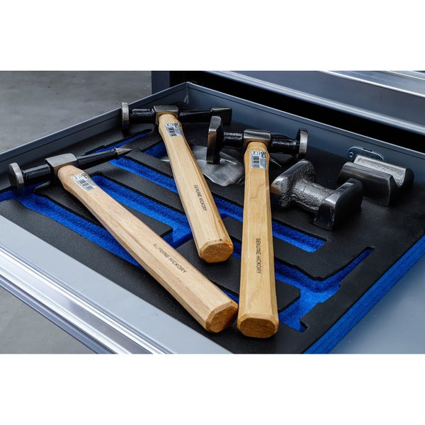 Ausbeul-Werkzeugsatz in Schaumstoffeinlage mit drei Karosseriehämmern mit Hickory-Stielen und verschiedenen Handfäusteln in einer Werkzeugschublade.