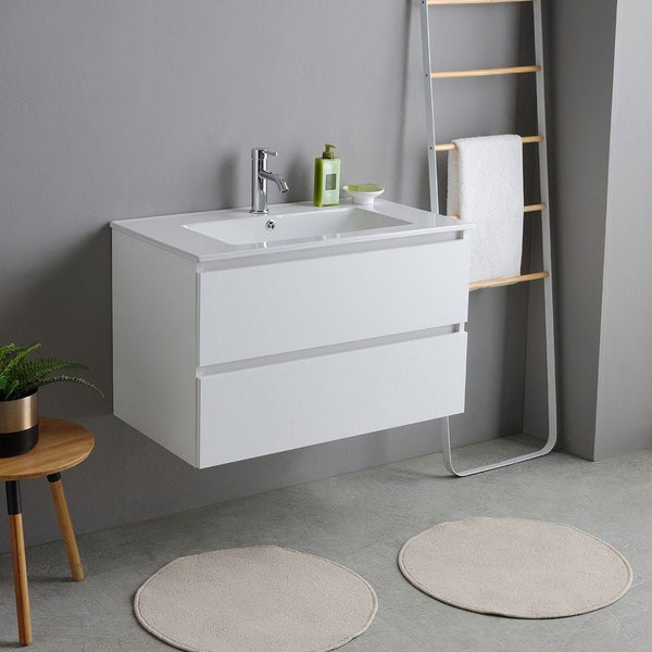 Wandhängender Waschbeckenunterschrank mit zwei Schubladen und integriertem Waschbecken in einem modernen Badezimmer mit Handtuchleiter und Teppichen.