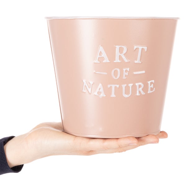 Roséfarbener Metallübertopf mit der Prägung Art of Nature, zur Veranschaulichung der Größe in einer Hand gehalten.