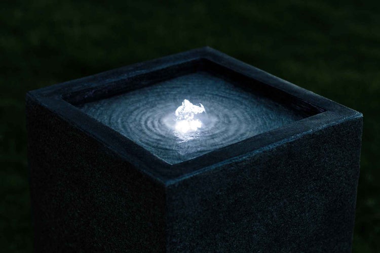 Wasserspiel mit sprudelndem Wasser in einem quadratischen Becken