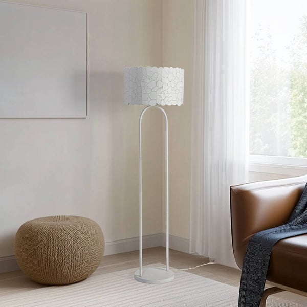 Stehleuchte mit gemustertem Lampenschirm und braunem Sitzhocker in einem Wohnraum