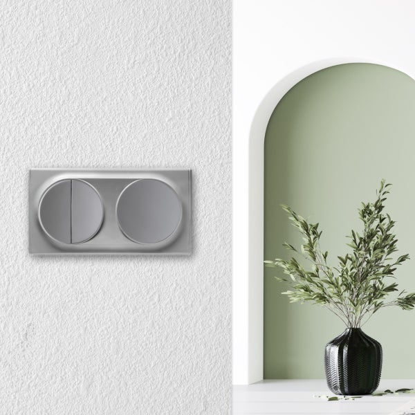 Doppelwippschalter in einer modernen Wohnraumsituation mit einem Lichtschalter auf einer strukturierten Wand neben einer Torbogen Nische.